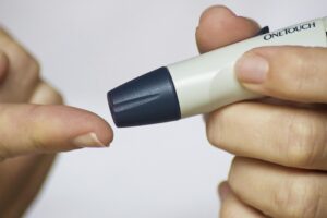 Persona pinchando su dedo para medir su nivel de glucosa
